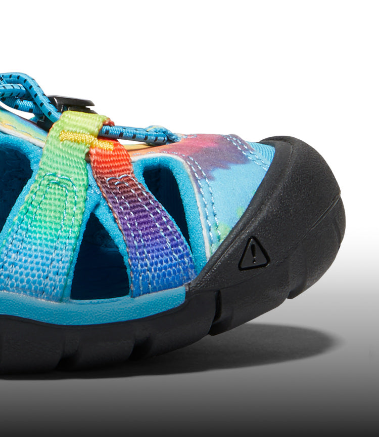 A close-up of a blue and tie-dye Seacamp kids' sandal.