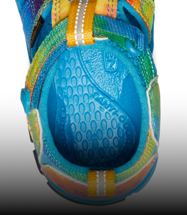 A close-up of a blue and tie-dye Seacamp kids' sandal.
