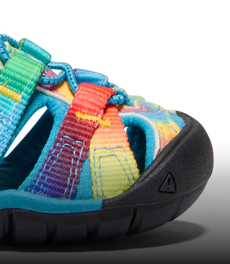 A close-up of a blue and tie-dye Seacamp kids' sandal.