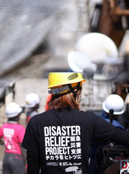 Disaster relief worker with hard hat receiving direction at a flooding site