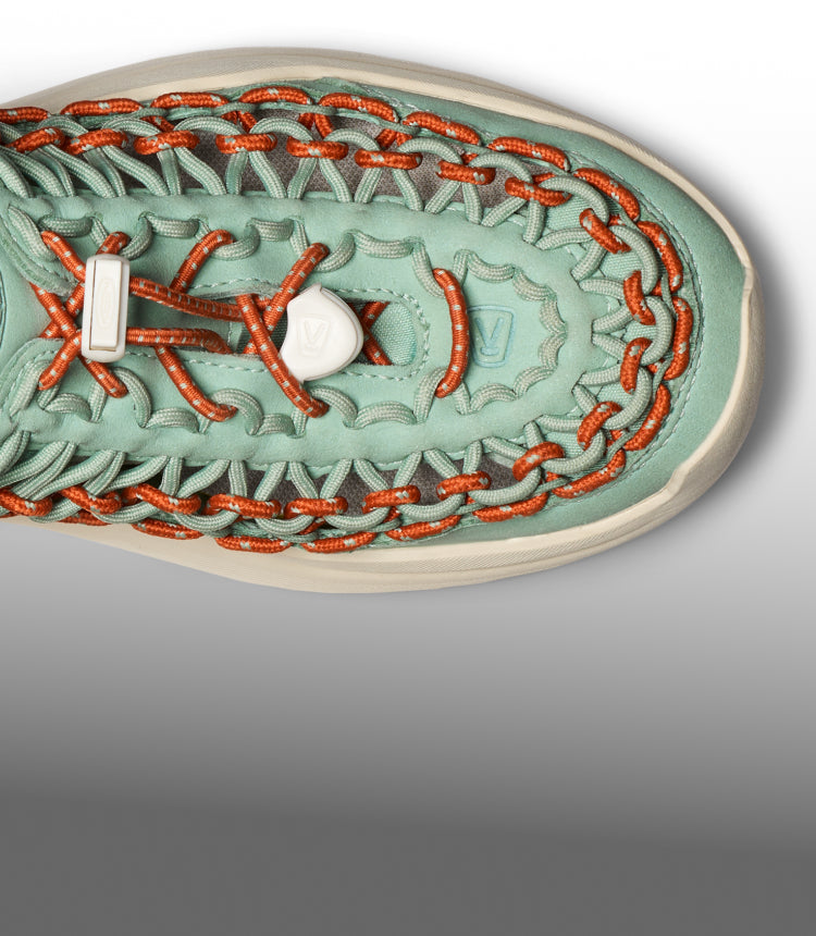 An overhead view of a mint green and orange KEEN UNEEK sandal.