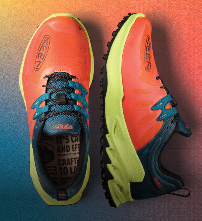 Close up of Zionic hiking shoes on orange and blue gradient background
