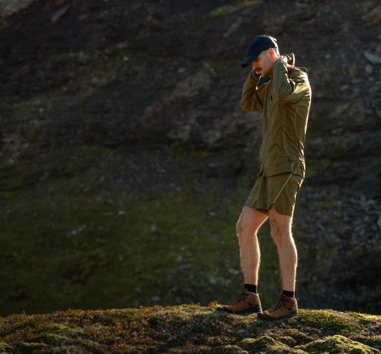A person standing on a mossy rock outside, wearing Targhee IV hiking boots.