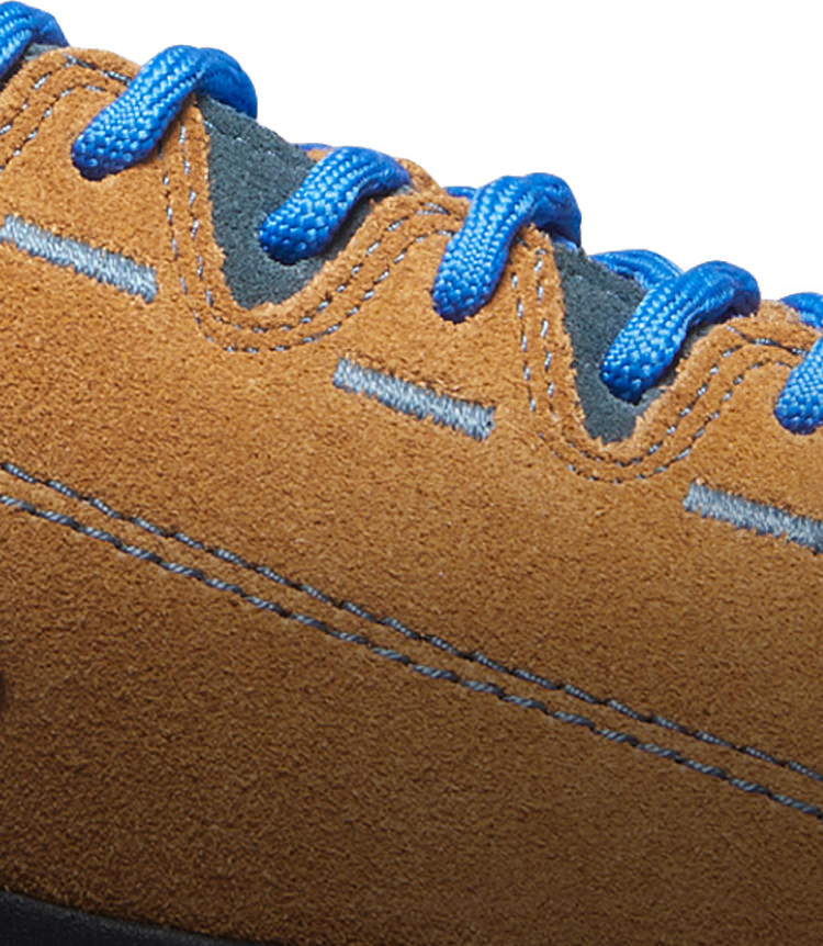 A close-up of a brown, suede Jasper shoe with blue laces and stitching.