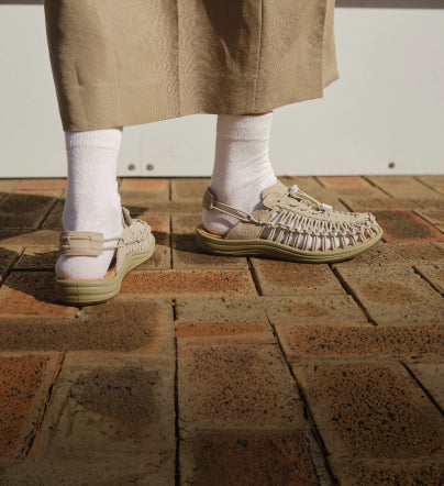A person wearing cream KEEN UNKEEK sandals.