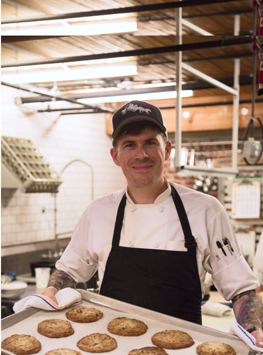 Chef holding a tray of fresh-baked cookies at the Keen Canteen