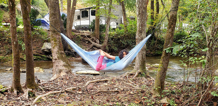 A girl relaxes in a hammock while camping