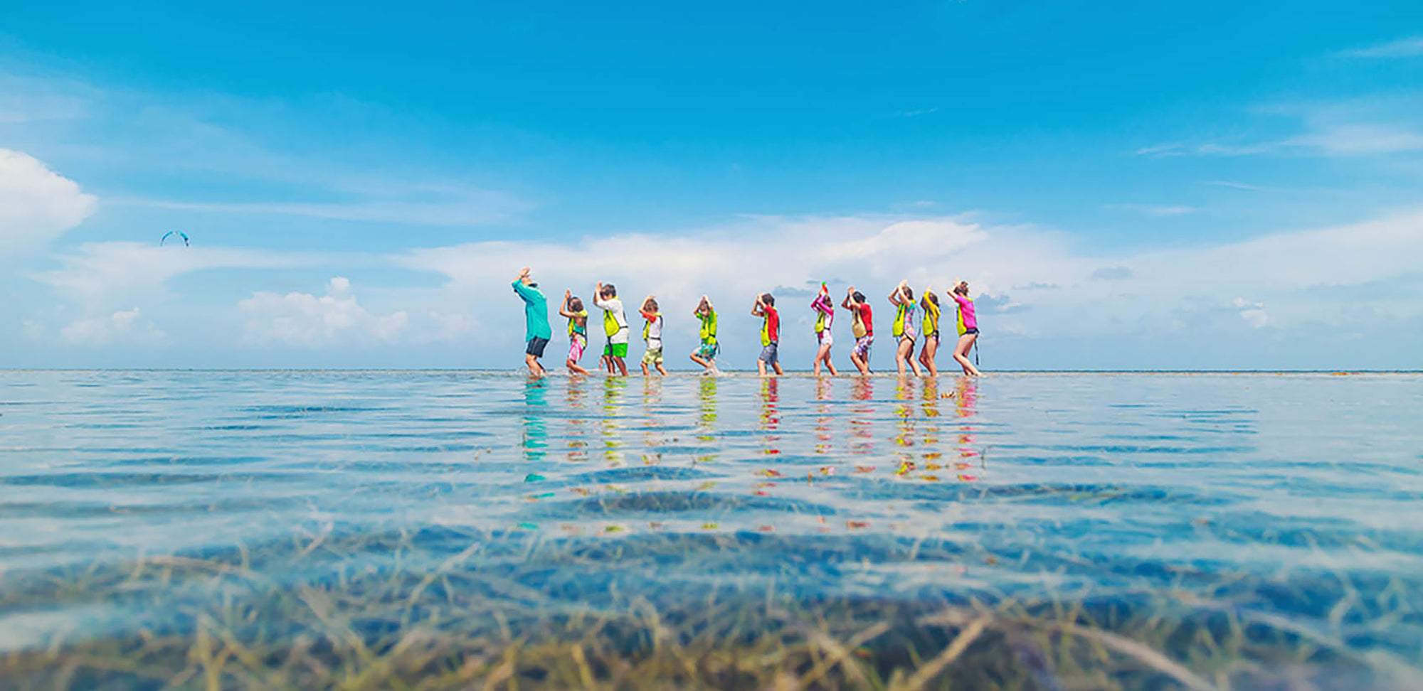 A group of children walking in the ocean