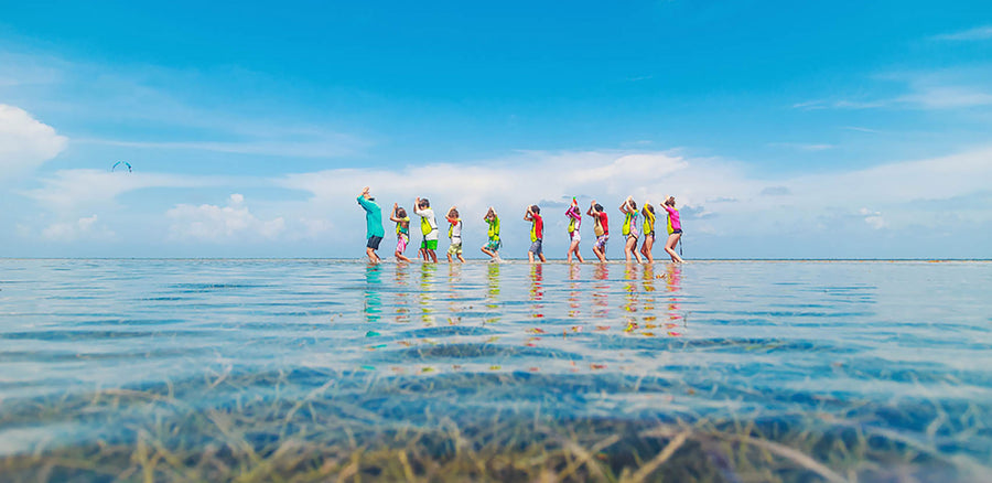 A group of children walking in the ocean