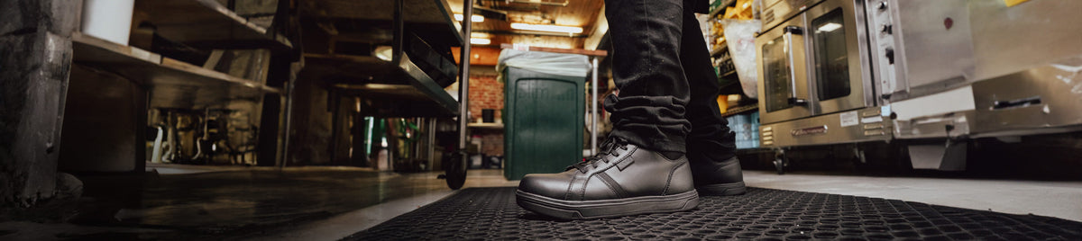 Person standing in an industrial kitchen wearing KEEN non-slip shoes.