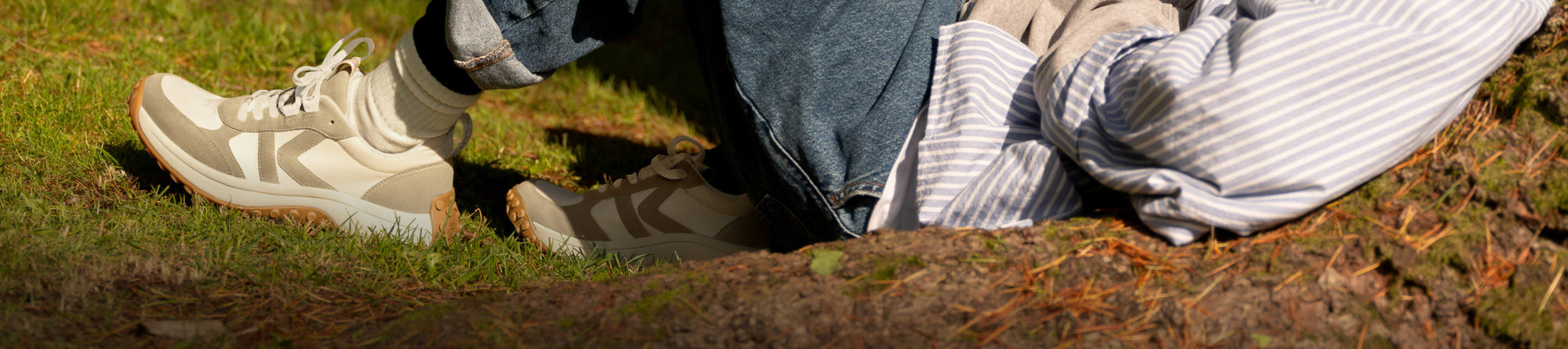 man leaning against a tree showing legs and torso only