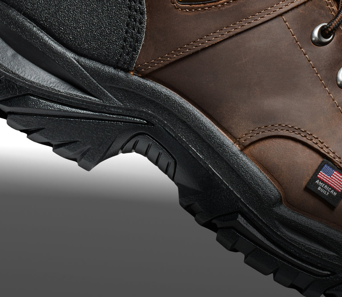 A close-up of the sole of a brown KEEN work boot, with a small American Built tag.