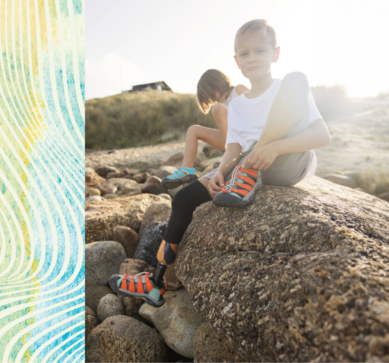 Two young boys, one with a bionic leg, sitting on large boulder while wearing orange and blue Newport Boundless sandals. 