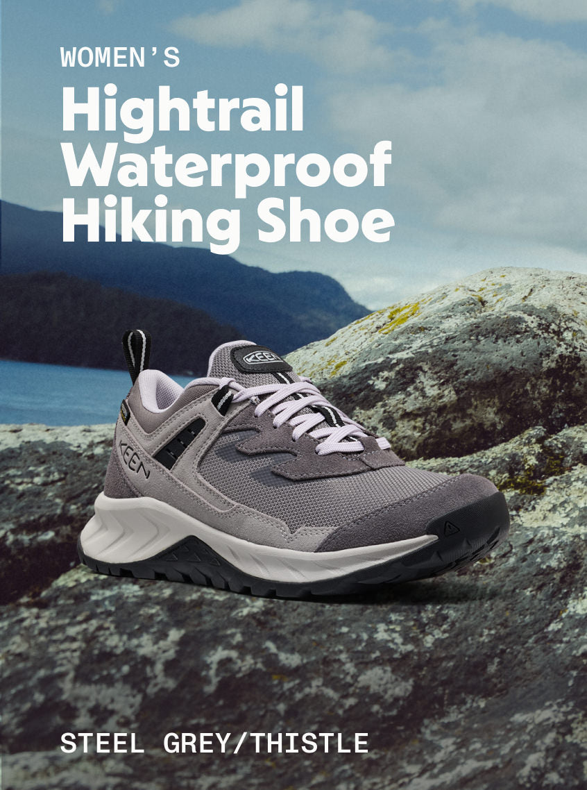 Product shot of Women's Hightrail Waterproof Hiking Shoe in Steel Grey and Thistle on riverfront rocks.