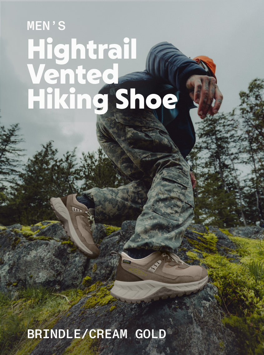 Man wearing Men's Hightrail Vented Hiking Shoe in Brindle and Cream Gold while hiking up a rocky trail. 