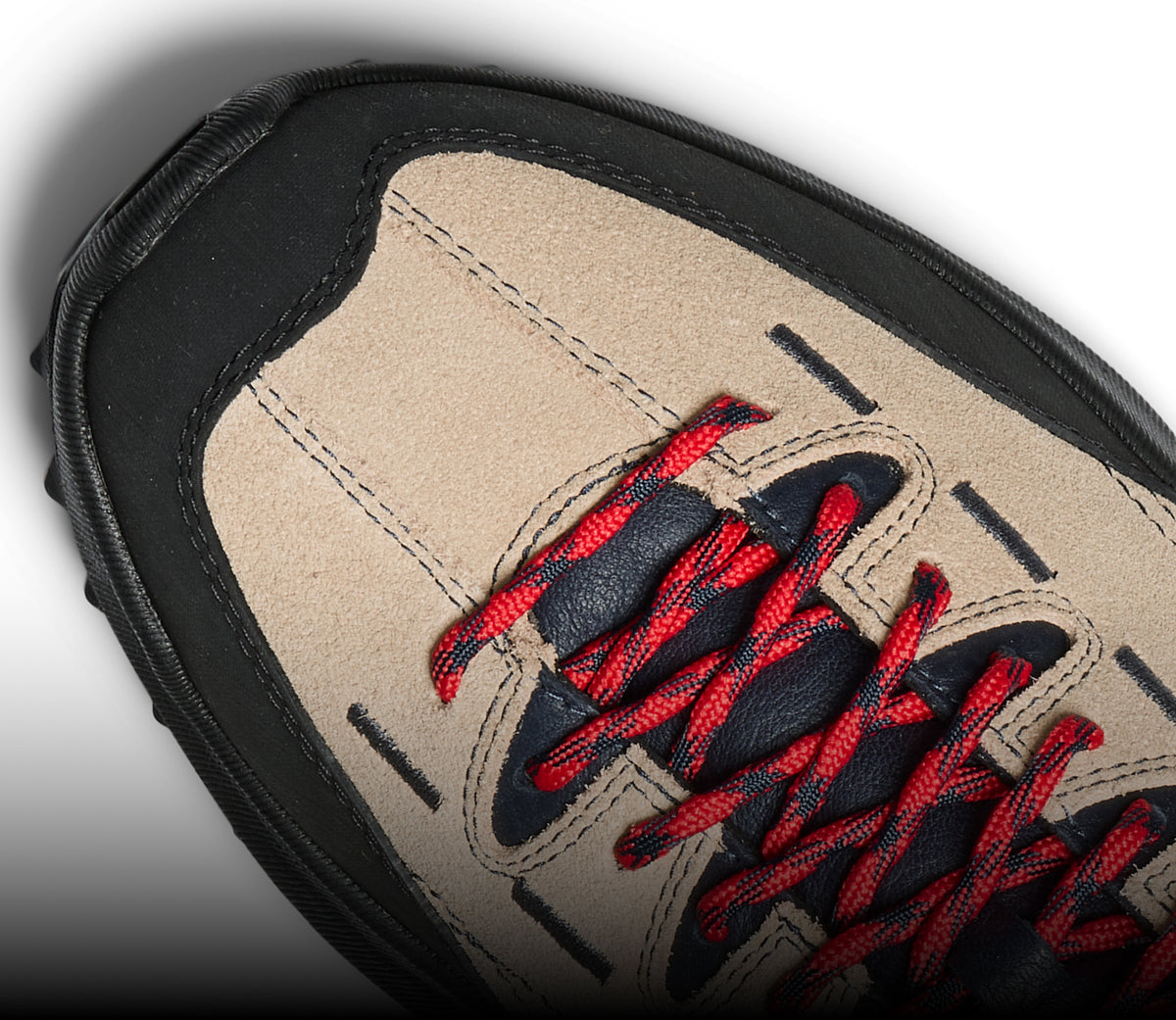 A close-up of a brown and black KEEN sneaker with red shoe laces.