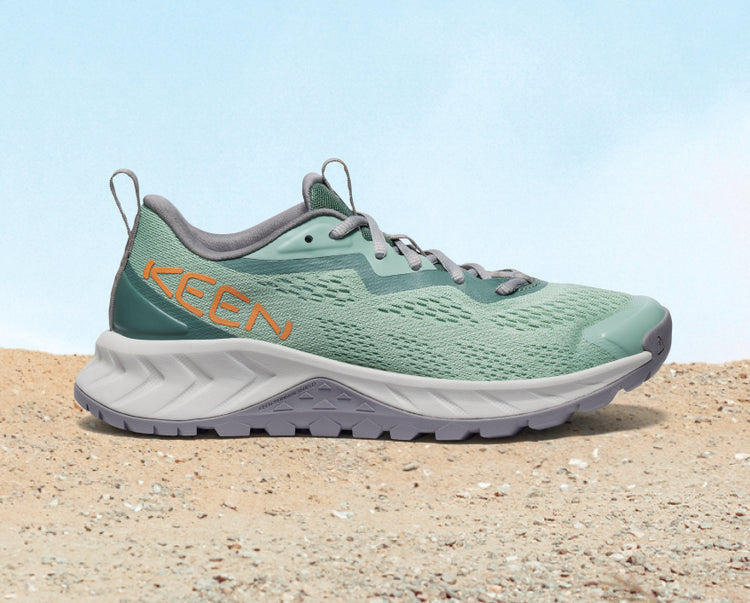 Product shot of women's light green and grey Versacore Speed hiking shoe on sand