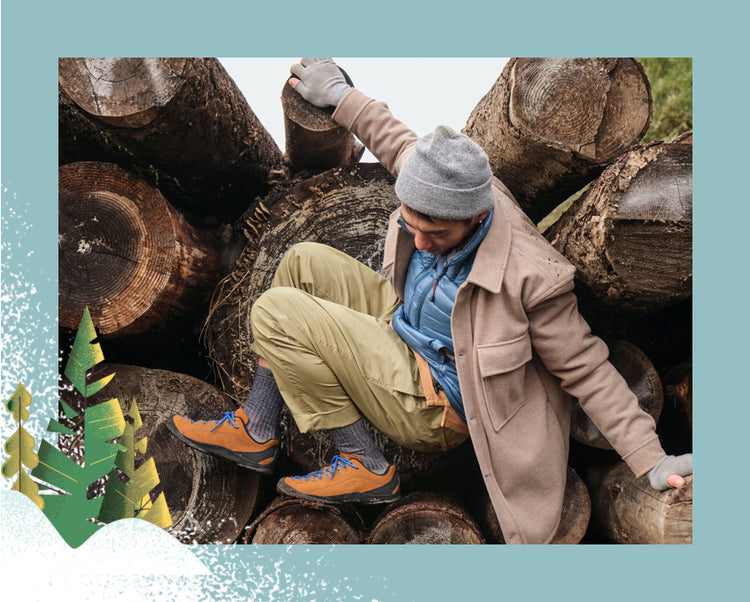 Man wearing orange jasper sneakers crawling across fallen trees