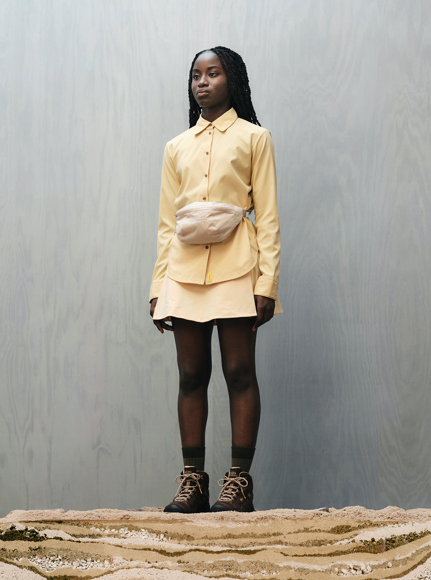 Woman wearing yellow button up and matching skirt with Hikerkind and Keen collaboration leather hiking boots.