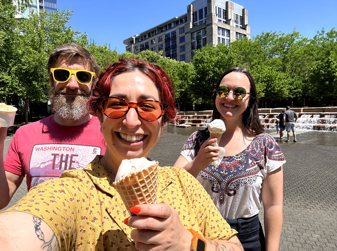 Three employees holding ice cream cones, smiling for a picture.