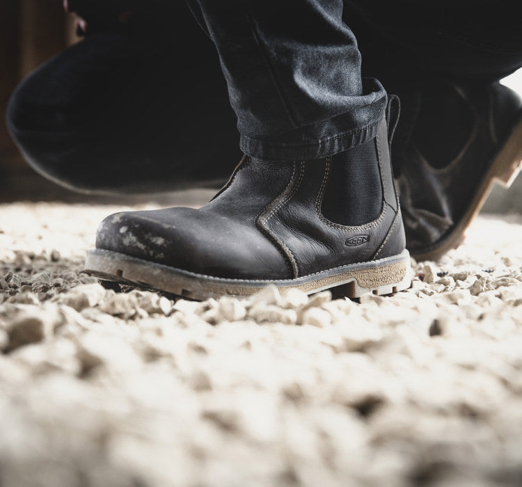 A person wearing a pair of black KEEN Chelsea boots.