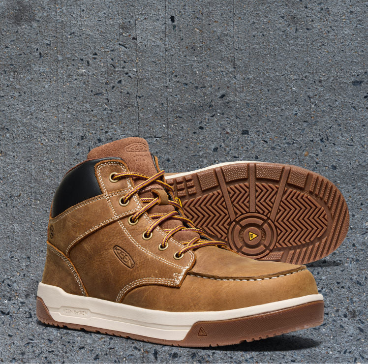 Product shot of men's Gibson work boot with carbon toe against gray pavement background