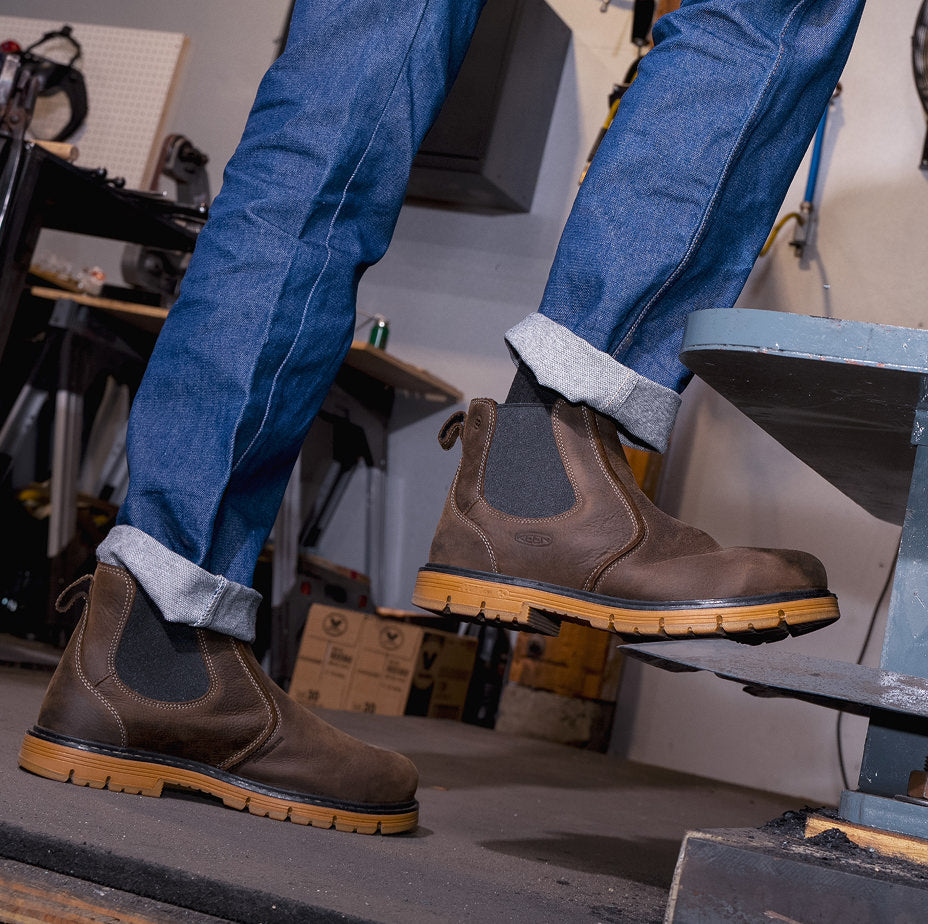 Knee-down shot of man in jeans and San Jose brown leather pull-on work boots in workshop setting 