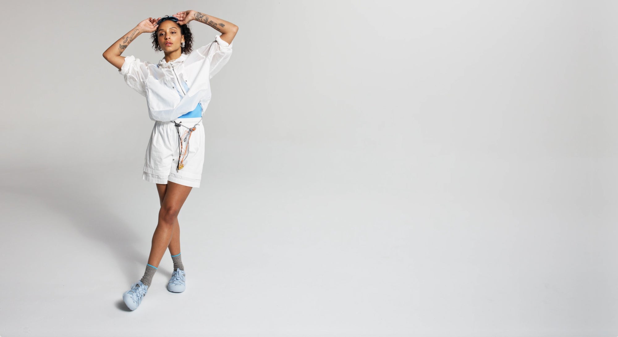 Woman in photo studio wearing an all white outfit with light blue monochrome Newport sandals 