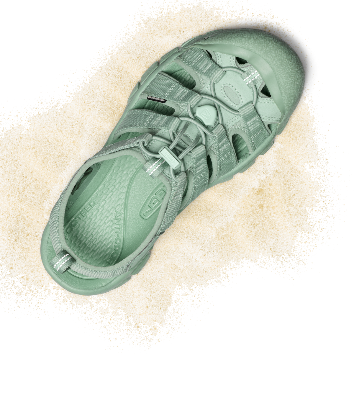 Product shot of light turquoise monochrome Newport water sandal with tan sand around it.