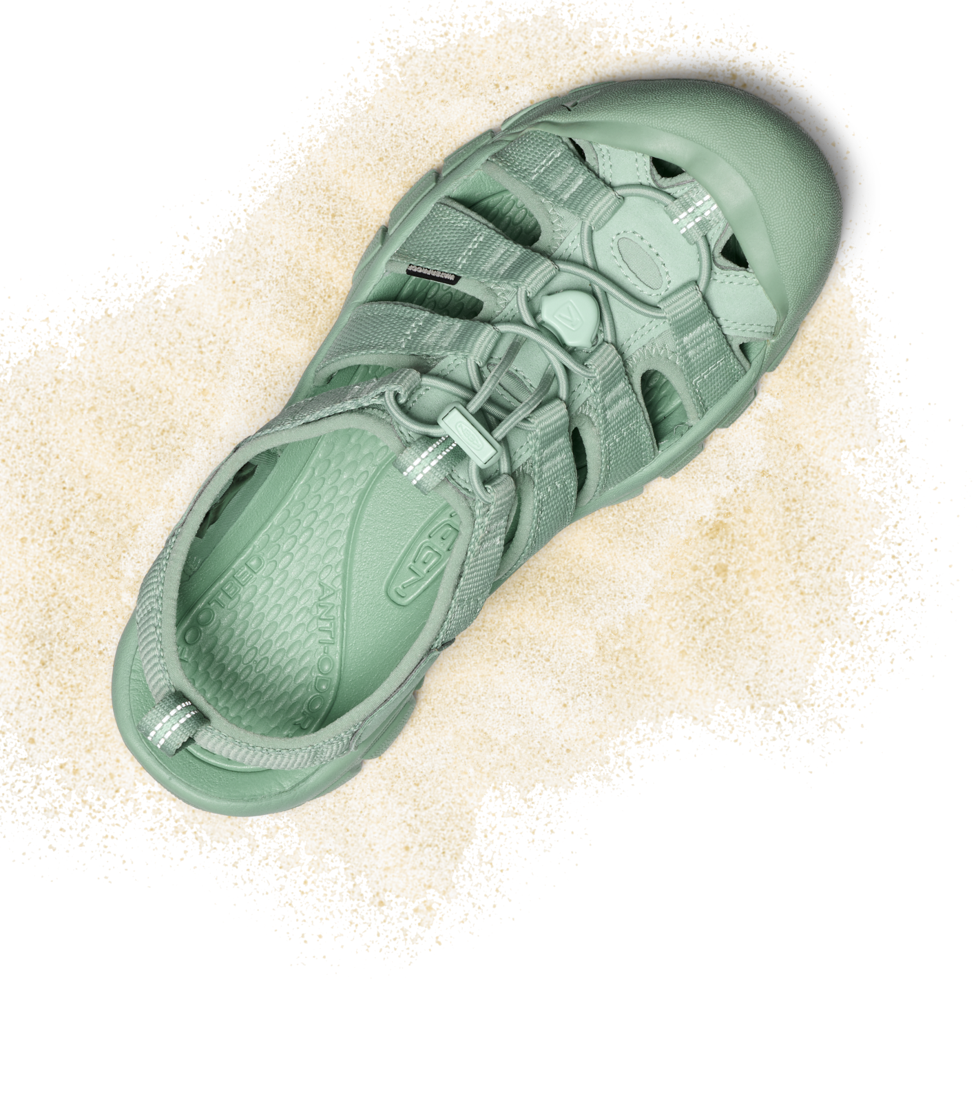Product shot of light turquoise monochrome Newport water sandal with tan sand around it.