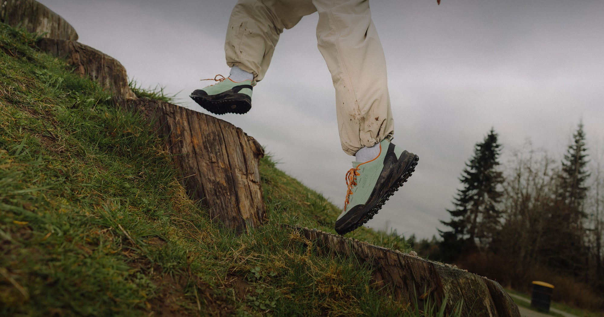 Waist-down shot of man in Jasper zionic sneakers jumping while traveling up a rocky cliffside
