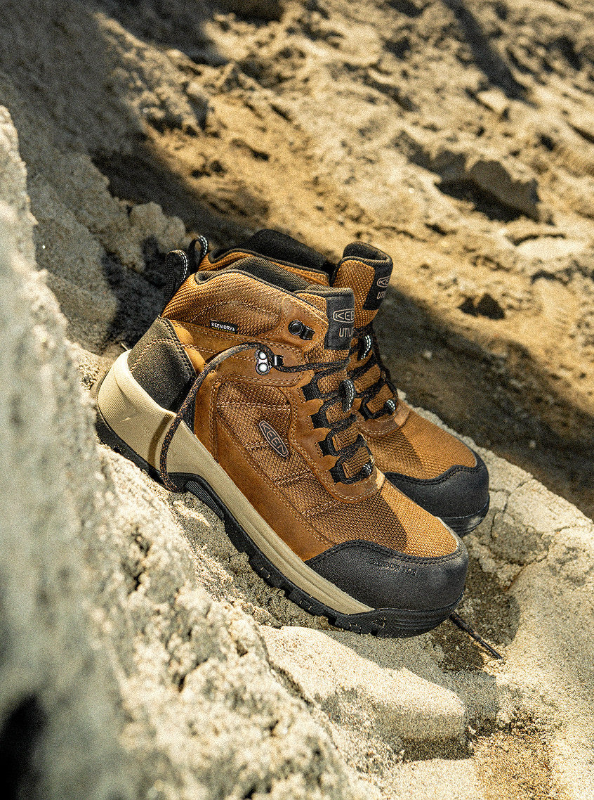 Product shot of a pair of Skokie leather work boots on sandy cliffside