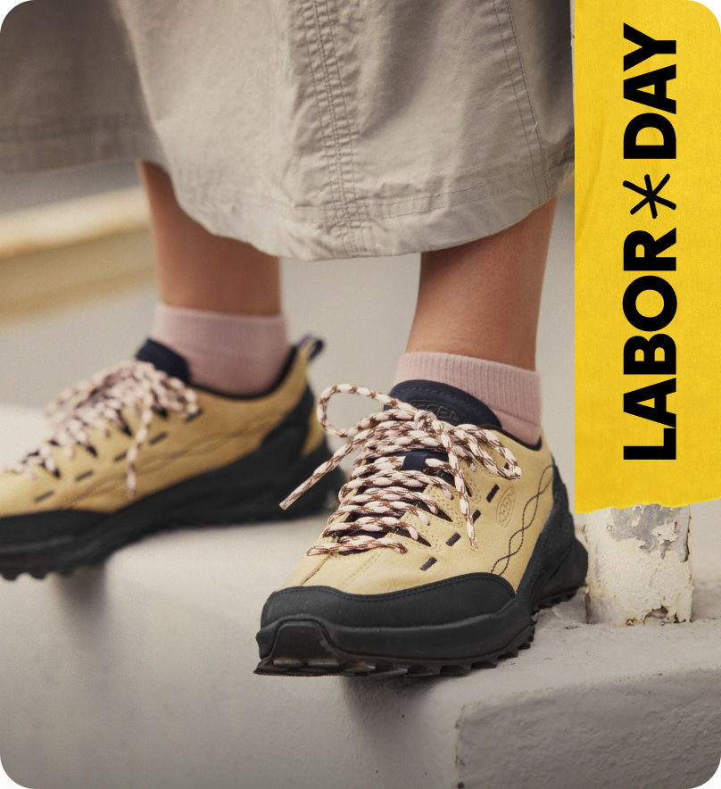 Knee down shot of woman in long cargo short wearing Jasper Zionic casual sneakers standing on stair ledge. Embedded text reads 