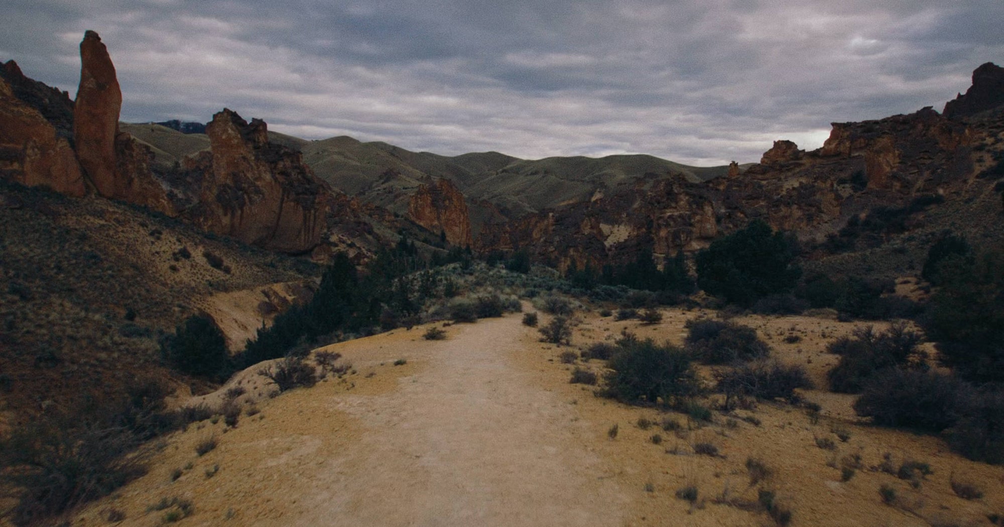 Three trail runners running through desert, rocky landscape in Keen shoes