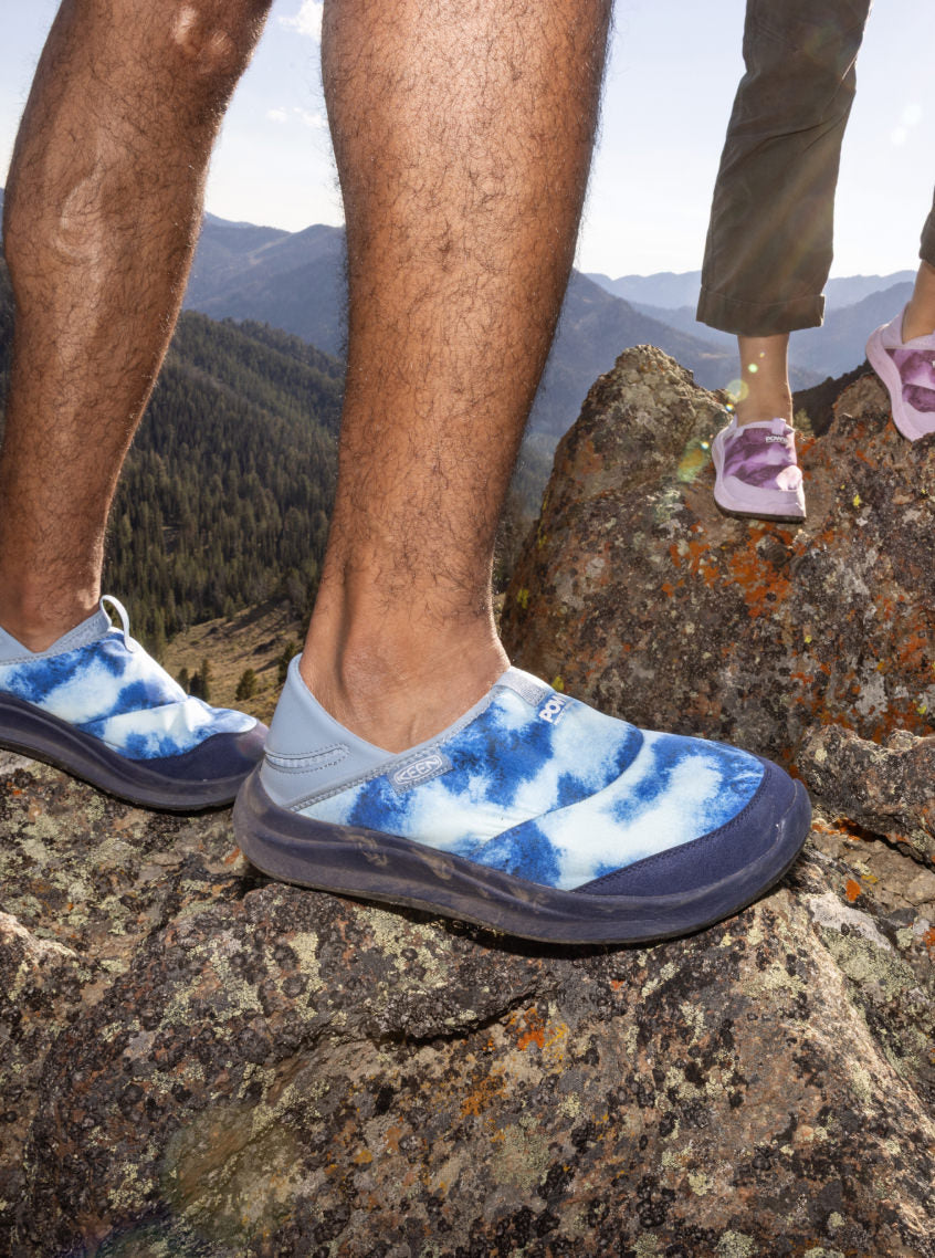 Close up of man and woman standing on a rock showcasing gradient artistic detail on collaboration Whyser shoes