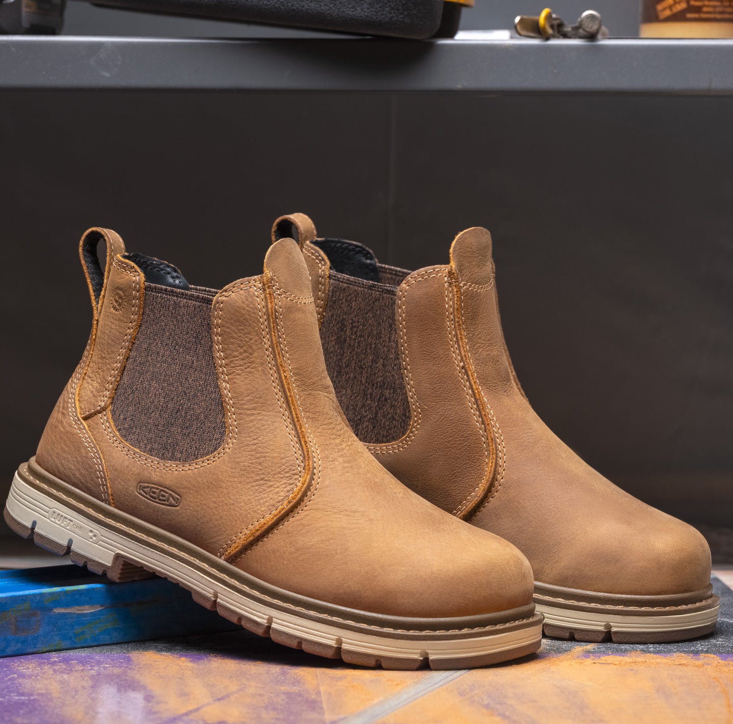 Product shot of women's brown chelsea work boot in warehouse setting. 
