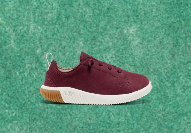 Product shot of kids' burgundy leather sneaker, featuring a durable rubber sole, ideal for casual wear and comfort.