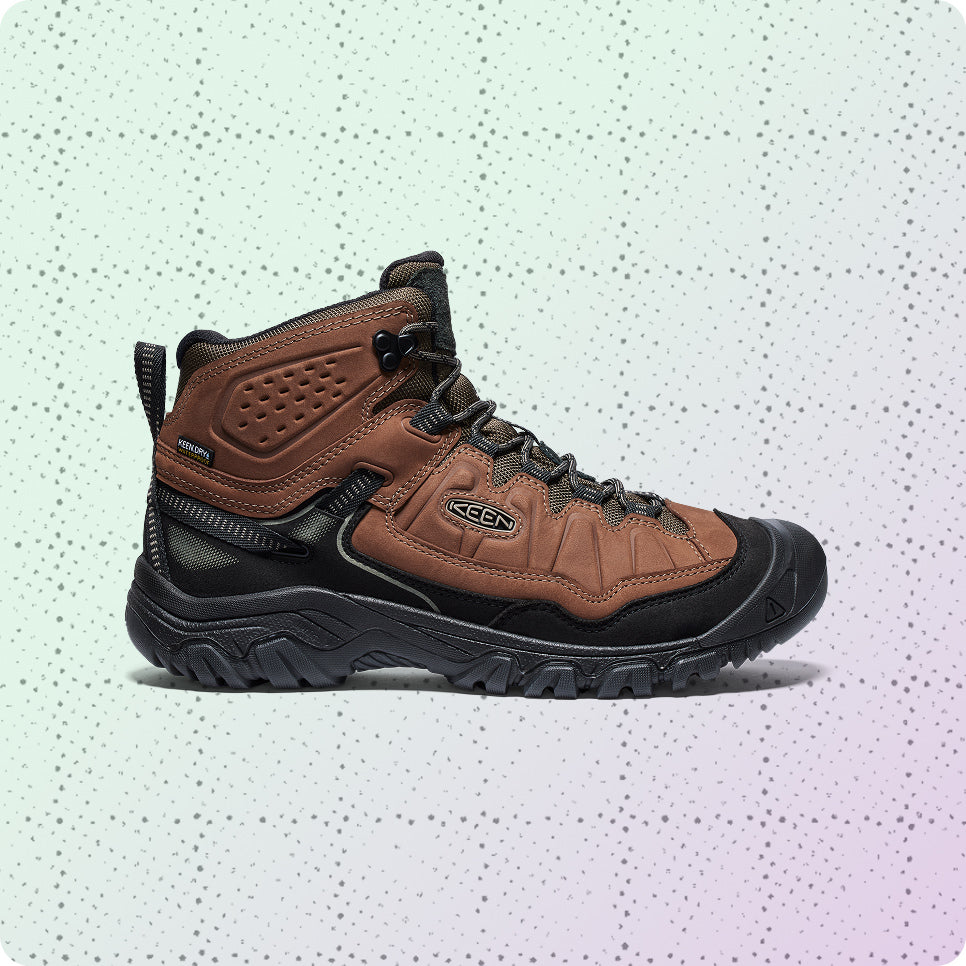 Mens brown leather, waterproof hiking boot on a dotted grid wrapping-paper background.