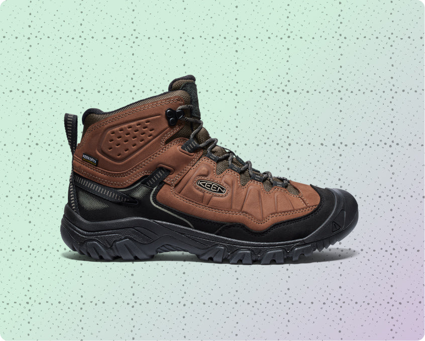 Mens brown leather, waterproof hiking boot on a dotted grid wrapping-paper background.