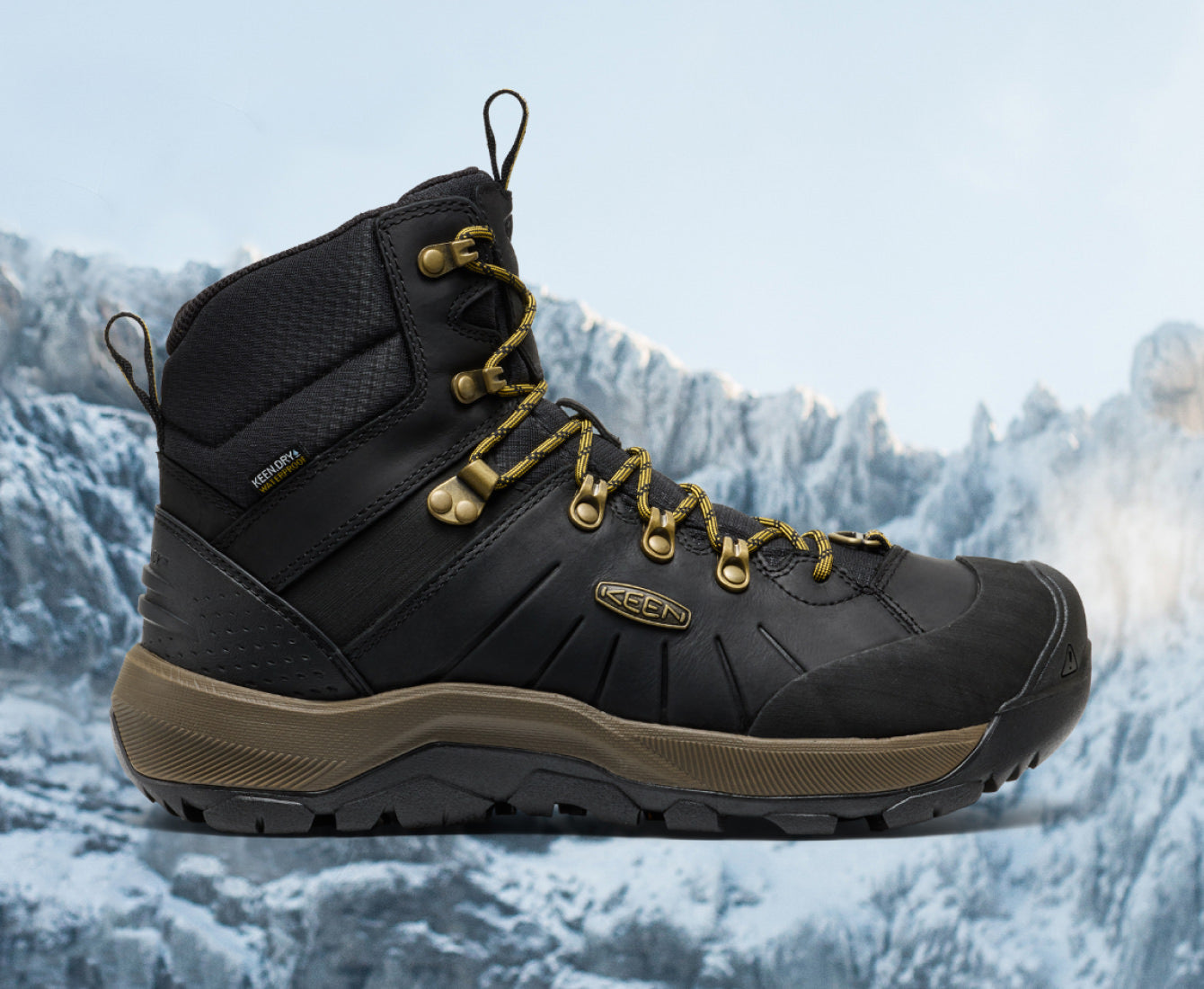 Insulated leather black winter boot with gold and yellow lacing against winter mountain background