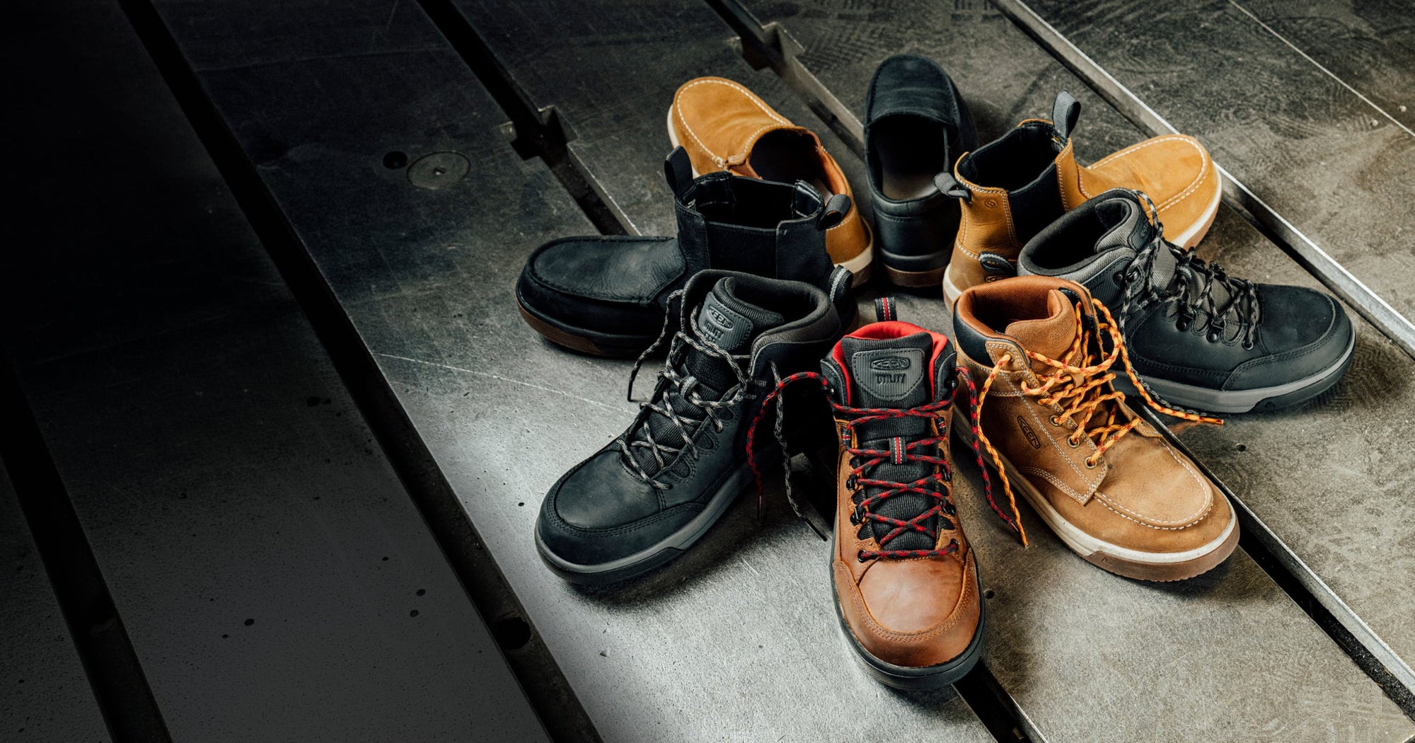 A circle of shoes displaying the new Gibson utility collection on an industrial floor.