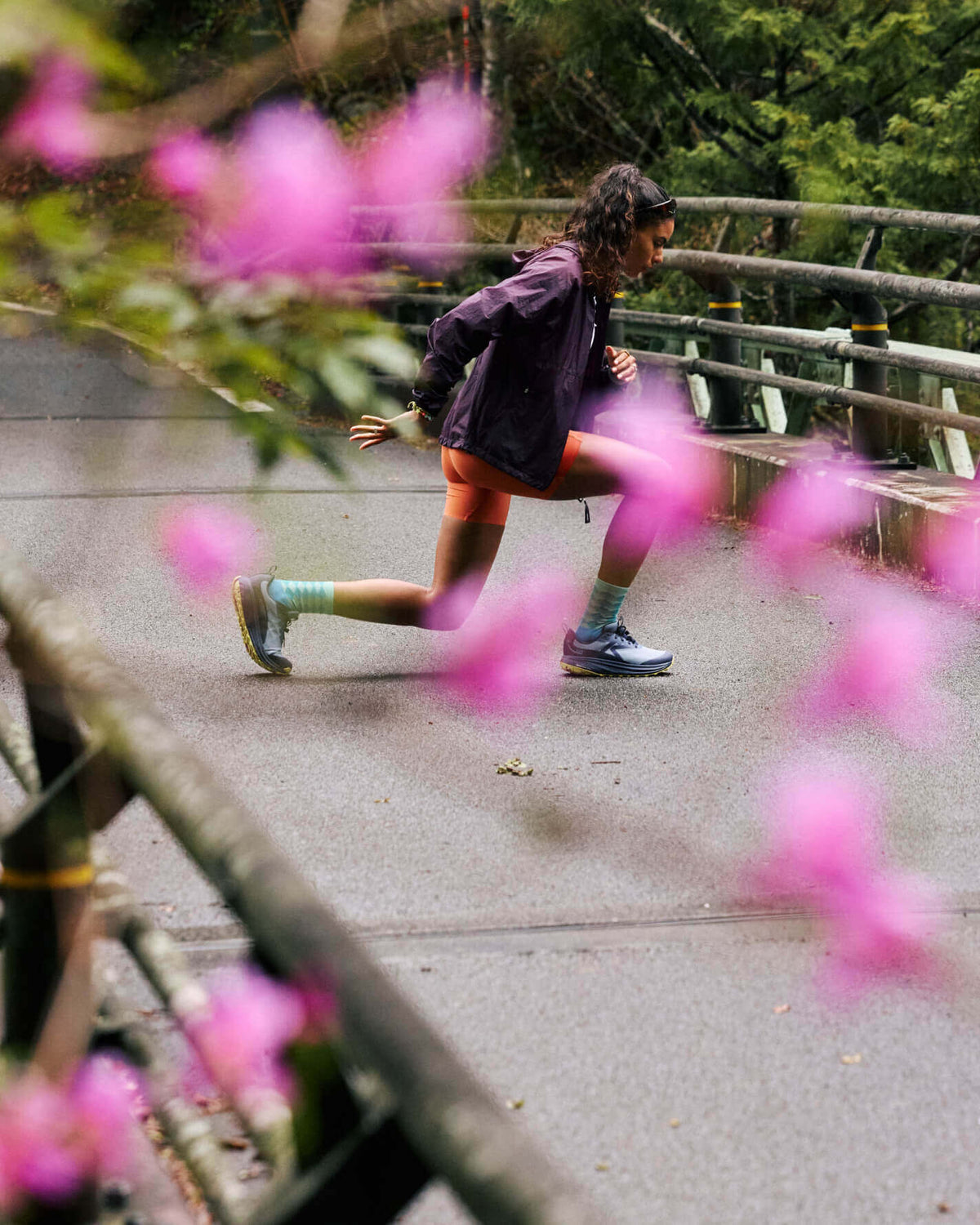 Woman doing lunges on paged bridge while wearing KEEN Roam running shoes