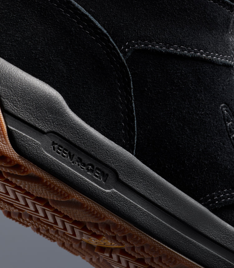 A close-up of the sole of a black KEEN boot, featuring Re.GEN technology.