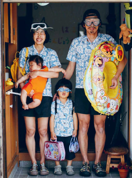 parents with two young children wearing googles, hawaiian shirts, and newport sandals in doorway