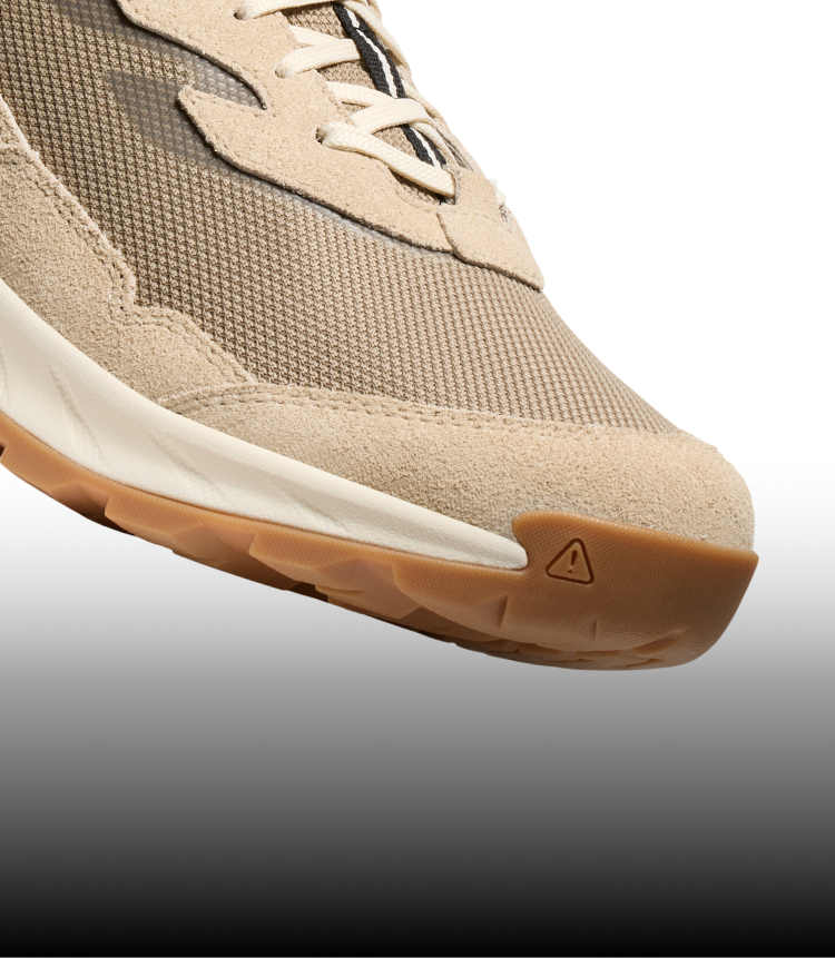 A close-up of a cream-colored Hightrail hiking sneaker with a camel-brown sole.