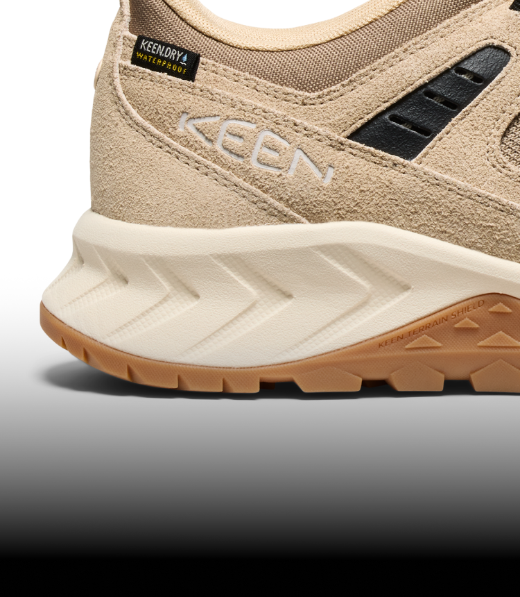 A close-up of the sole of a cream KEEN sneaker.