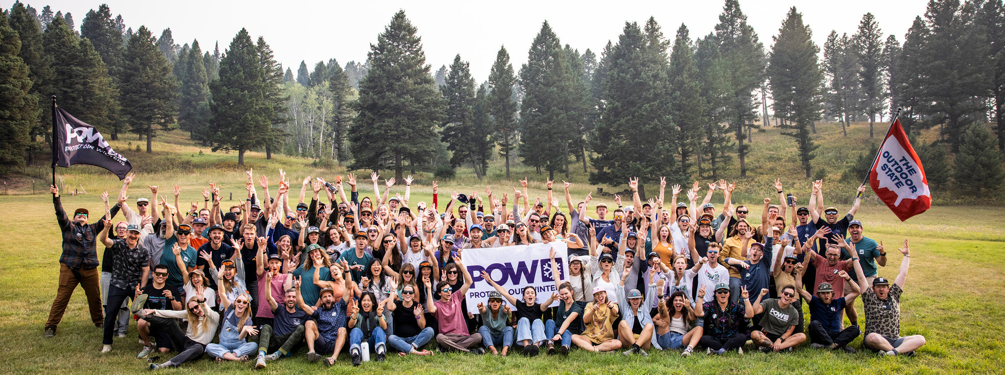 Protect Our Winters Team cheering in a field.