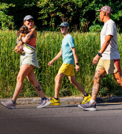 Three people walking in front of tall, grassy field in WK400 walking shoes. 