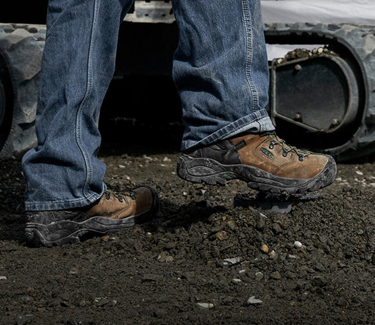 Knee down view of man wearing Pittsburgh energy boots walking through mud