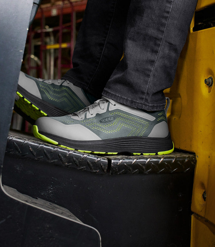 Close-up of Sparta 2 work sneaker on foot of man driving warehouse lift. 